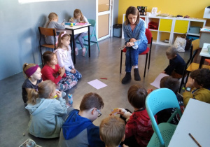 Nauczyciel czyta siedzącym w kręgu dzieciom